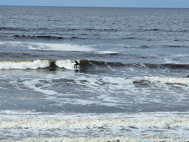 Surfer dropping into a chest high wave in front of the shop